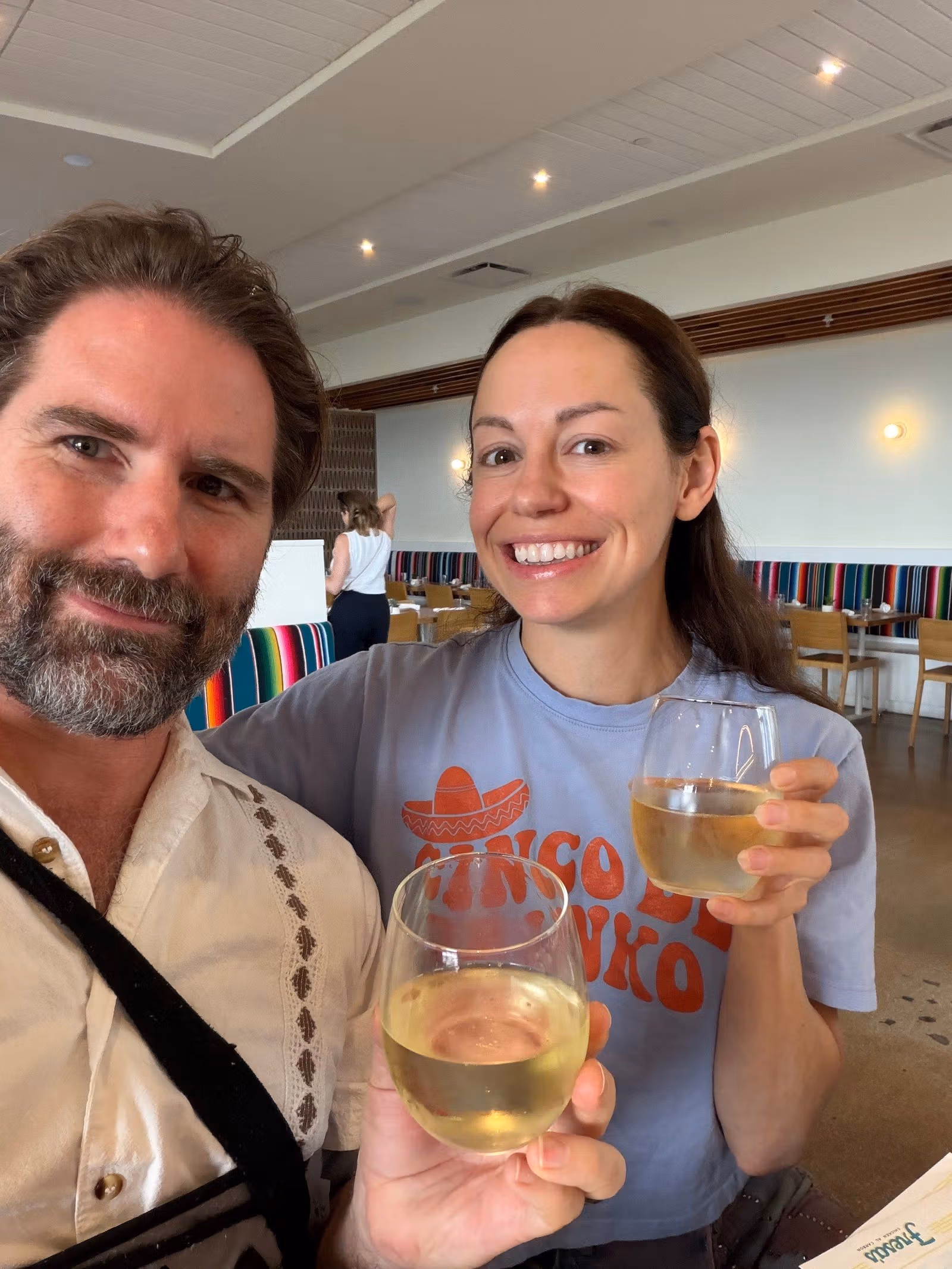 Mason and his wife smiling together and holding drinks at a restaurant