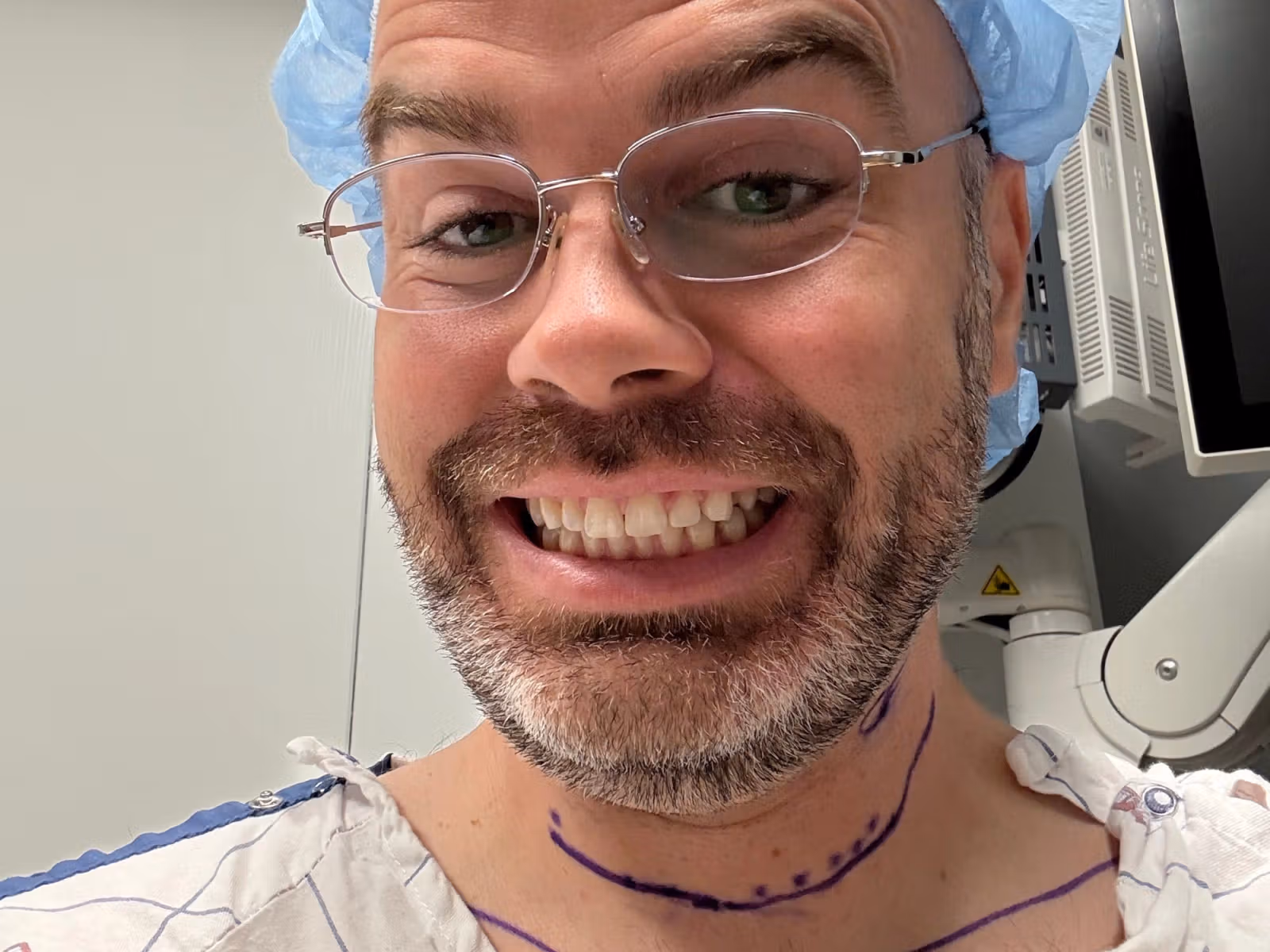 Shane smiling in a hospital gown with surgical markings on his neck before thyroid surgery